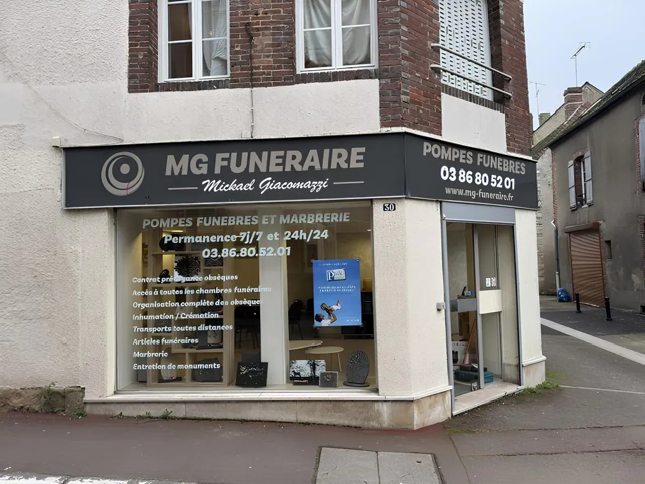 Devanture de l'agence MG Funéraire Mickaël Giacomazzi avec vitrine d'articles funéraires.